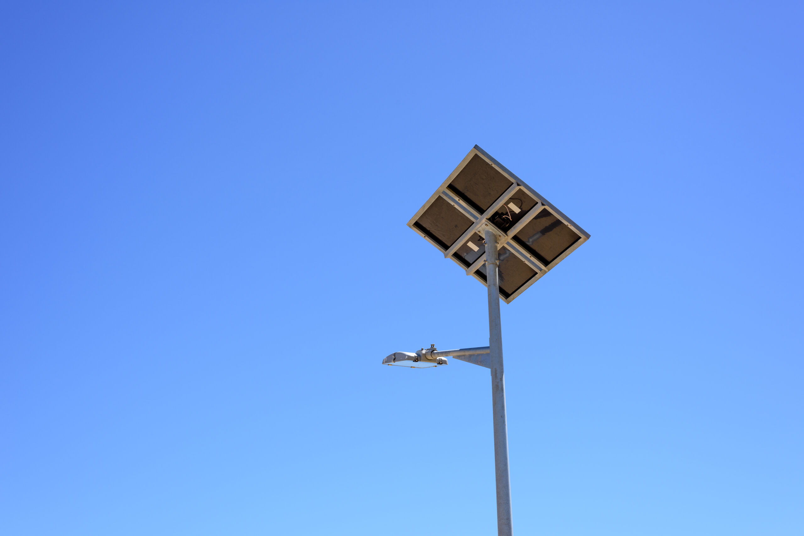 Street light with solar panel on blue sky background. Green ener